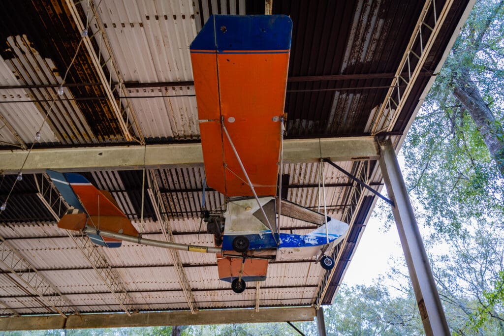 A plane made from repurposed materials hanging from a ceiling