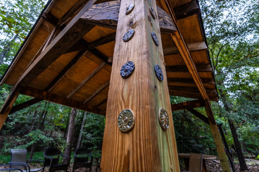 Abstract clay disks fixed to the wooden beam of a structure