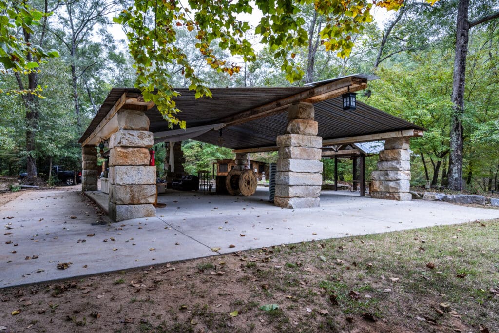 A large pavilion crafted from large stones and repurposed metal beams