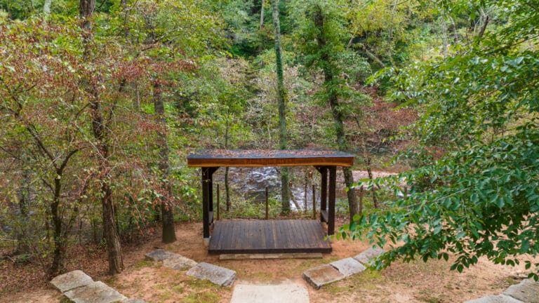 Rolling River Stage, seen sitting in the woods with a river running behind it