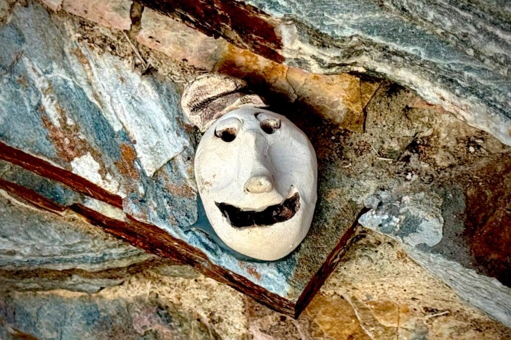 One of many faces hidden between the rocks on the Music Camp Honor Wall